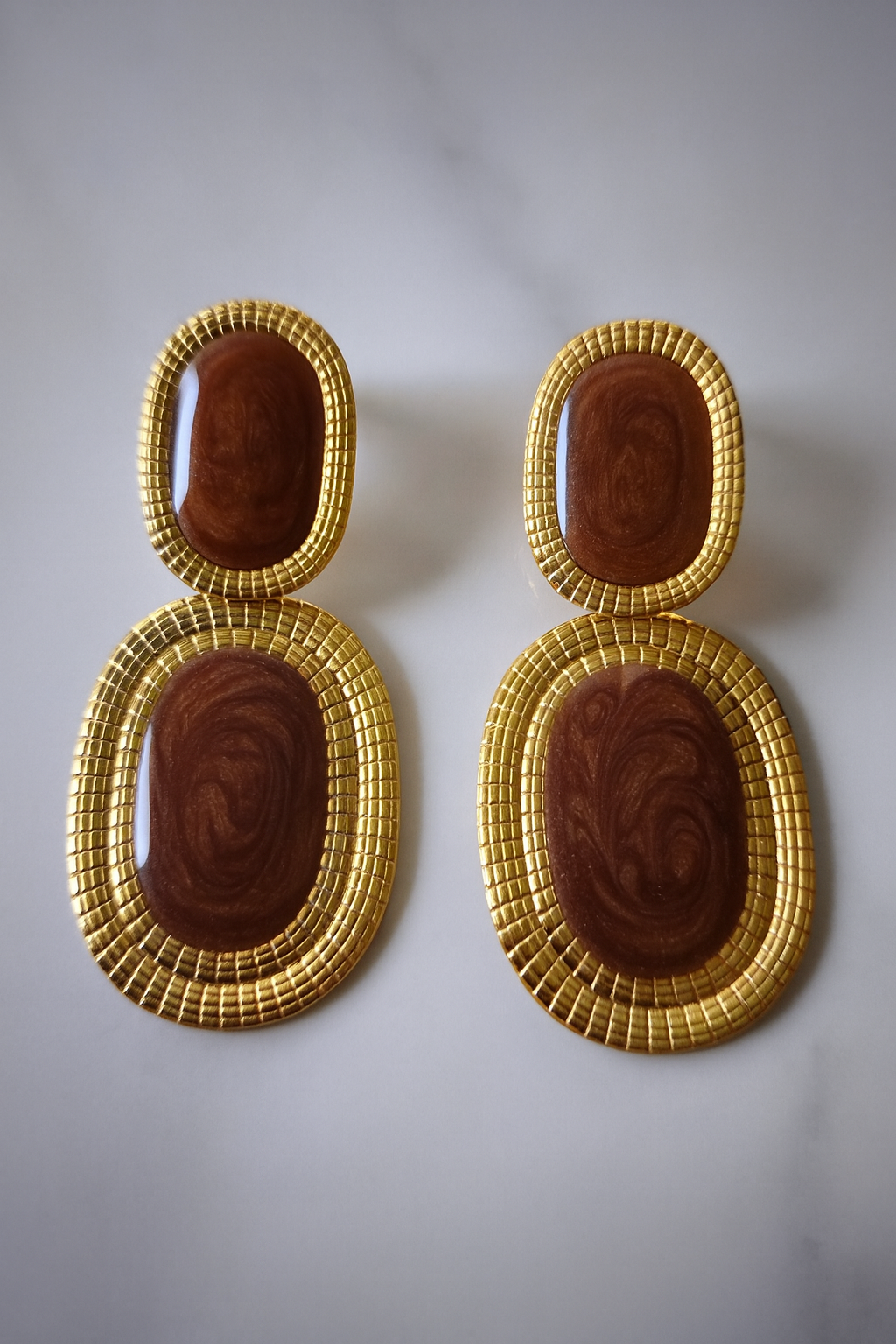 Boucles d’oreilles Likasi Brune en acier doré et résine brune marbrée, reflets terreux et chauds.