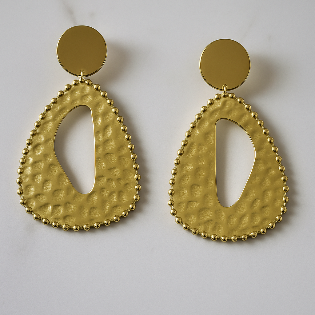 Packshot boucles d’oreilles Zama en acier doré texturé, forme goutte ajourée