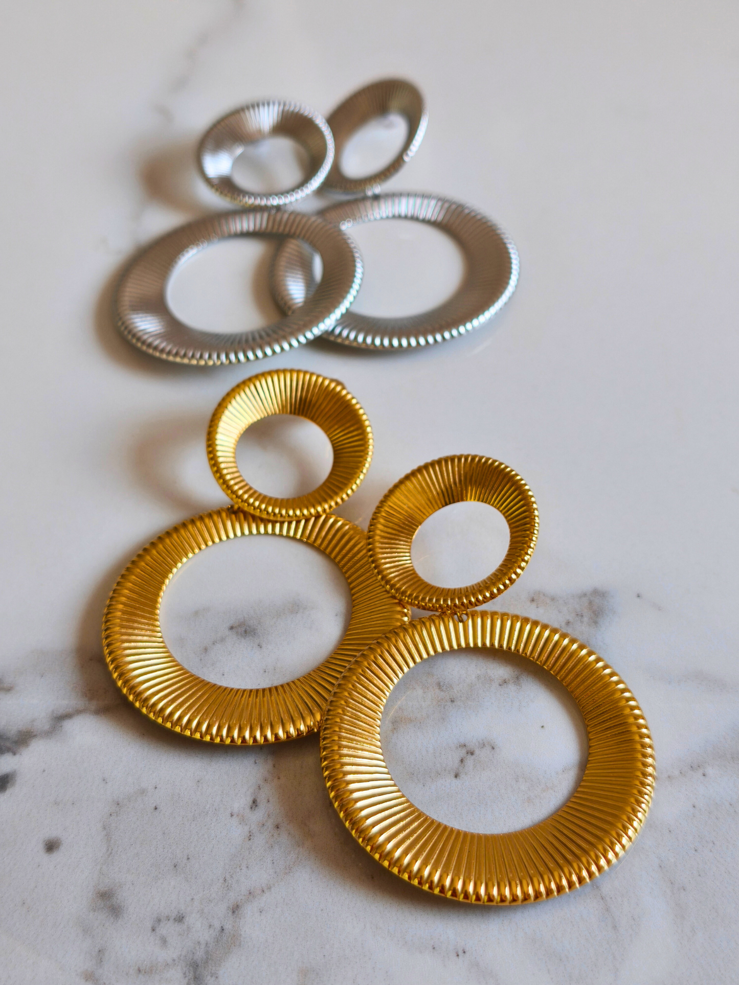 Boucles d’oreilles Asiba en acier doré texturé, vue de face