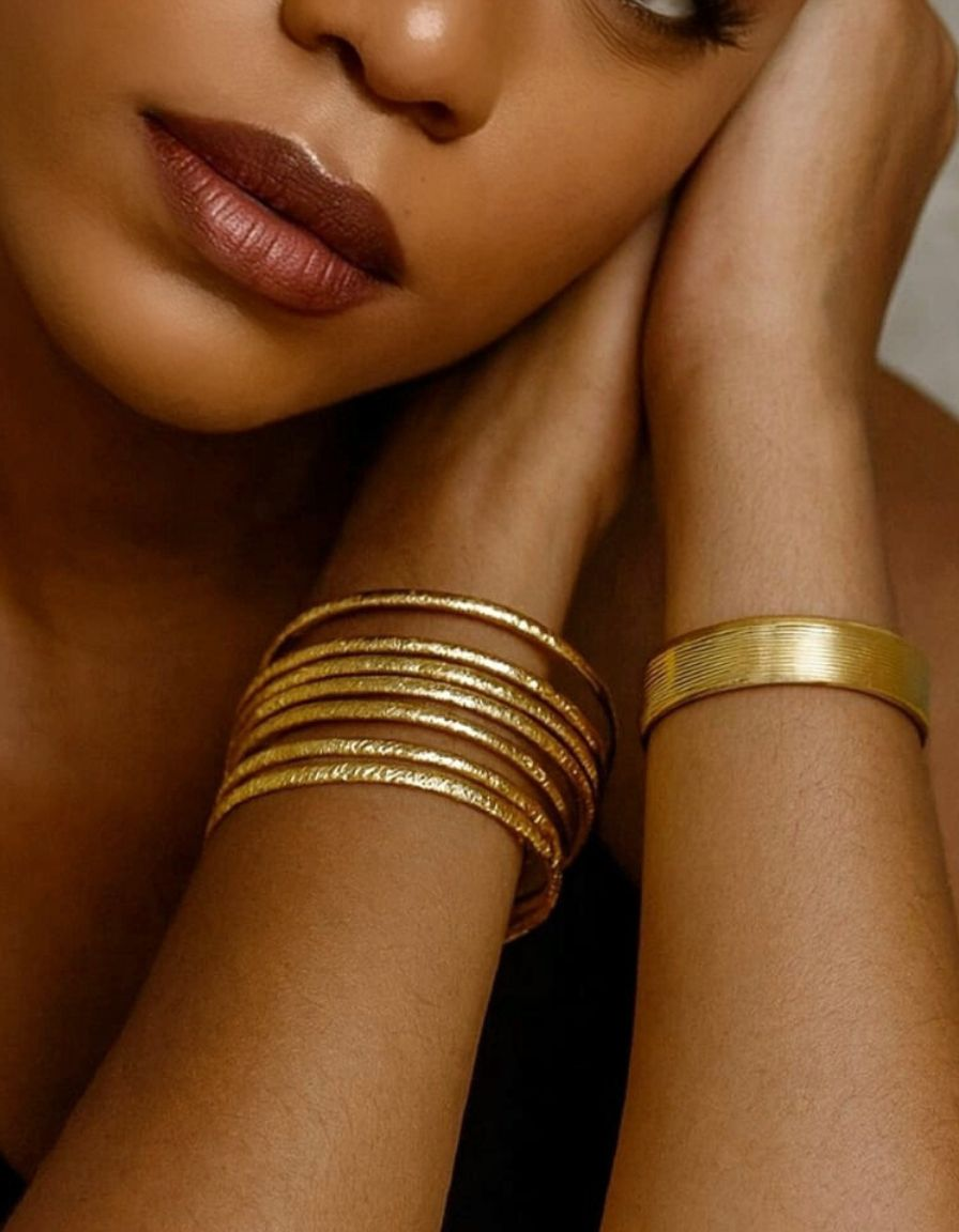 Femme noire portant plusieurs bracelets dorés et argentés MOUN’, collection Bracelets, modèle Nayela, style élégant et moderne.