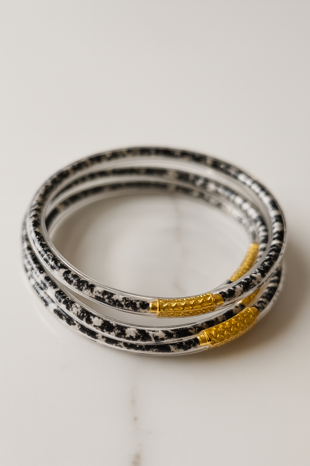 Bracelets Ndaya – lot de 4 joncs zébrés extrémités dorées, photo produit e-shop MOUN’