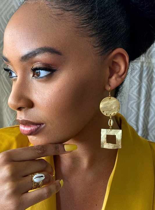 Boucles Caloucaera portées, laiton doré à l'or finmat et cauri africain