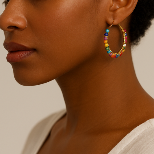 Boucles d’oreilles Soleya – créoles dorées ornées de perles multicolores portées par une femme noire, style chic et solaire