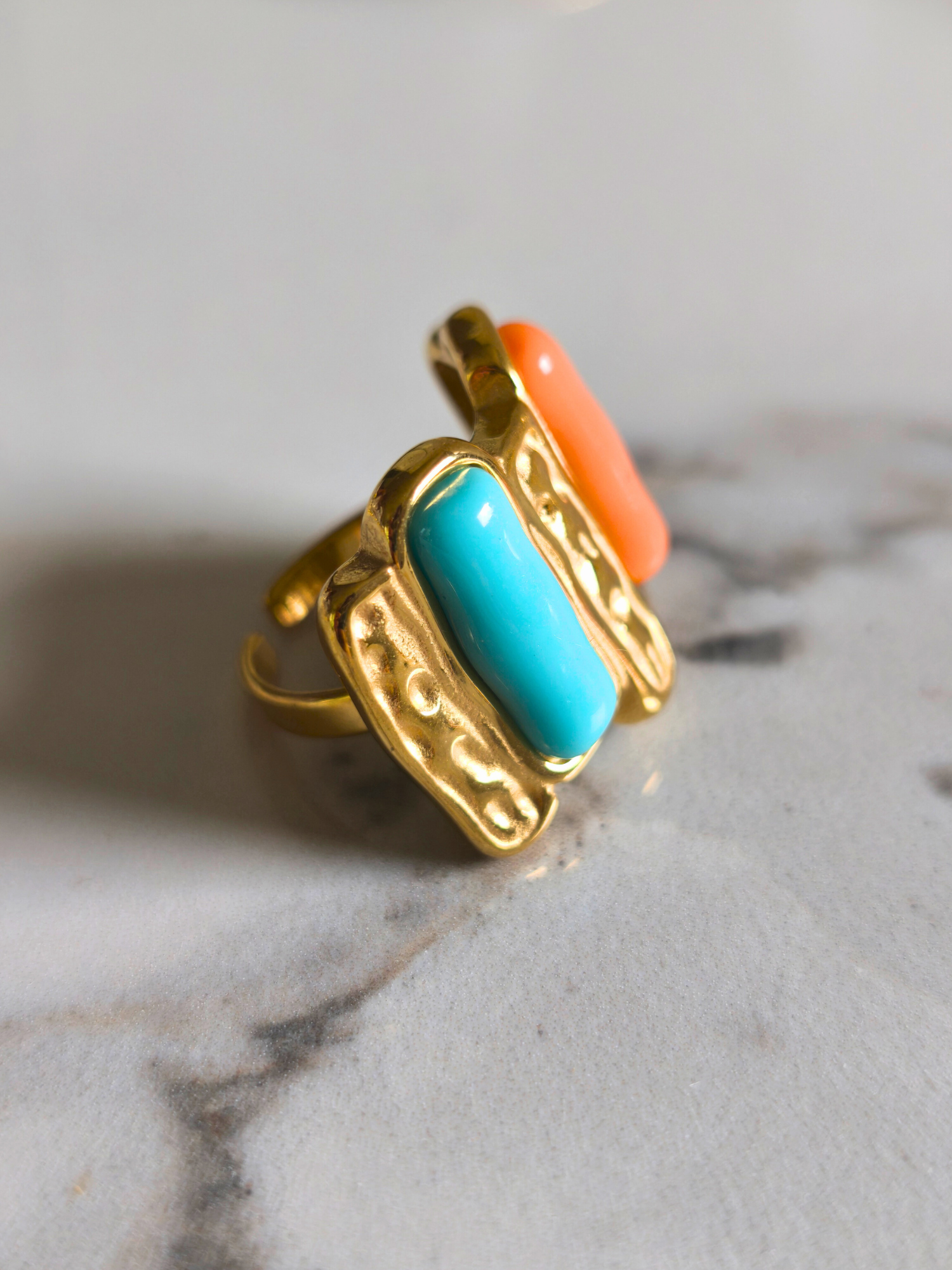 Vue de côté de la bague Madras en acier doré, émaillée turquoise et orange