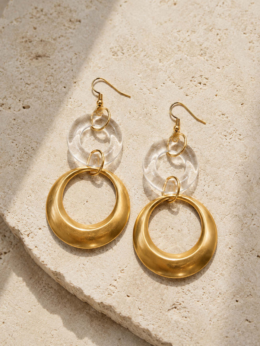 NANE — boucles d’oreilles dorées et transparentes en flatlay